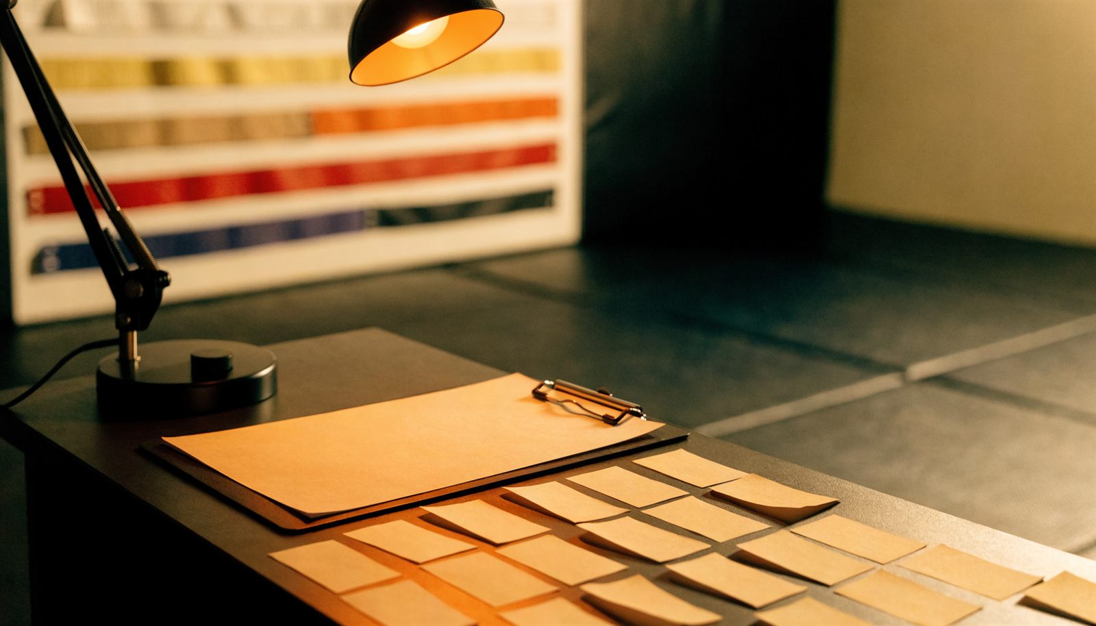 Academy front desk with blank attendance cards, a clipboard, and a belt-tone grading board beside training mats